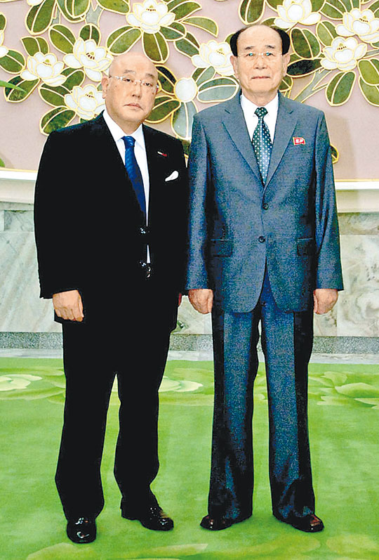 朝中社日前發布飯島勳(左)與金永南(右)會面的照片。