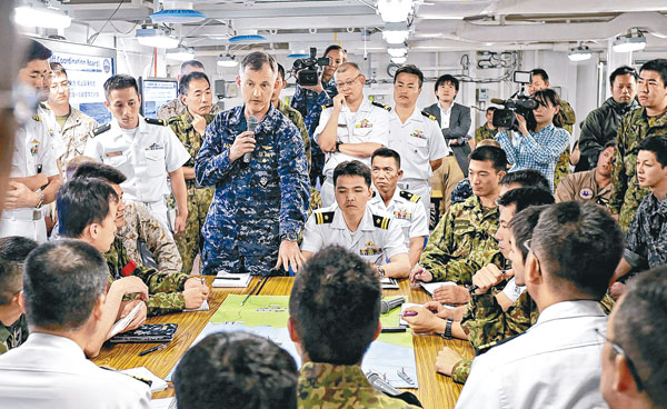 美軍與日本自衞隊成員討論魚鷹降落的準備工作。