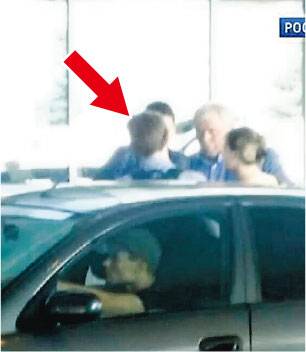 俄國電視台昨公開在俄羅斯機場拍得疑似斯諾登(箭嘴示)的照片。一直協助他的俄羅斯律師庫切列納(右)在他身旁。