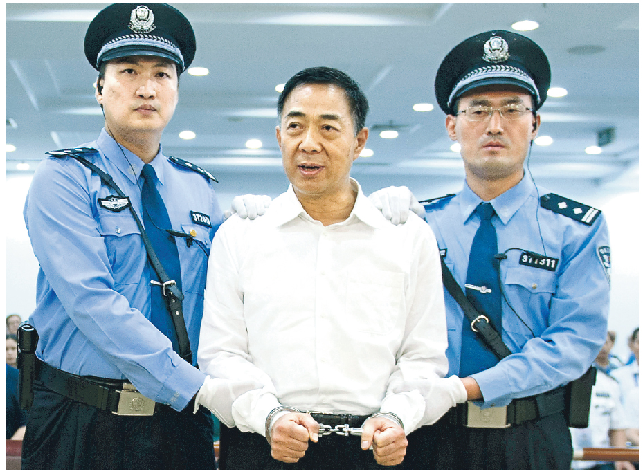 被告薄熙來(中)昨天聽判後情緒激動,被戴上手銬後雙拳緊握,其後在兩名法警押解下離開濟南中級法院5號庭。(新華社)