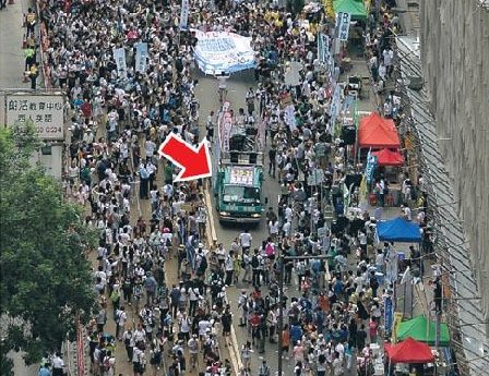 民陣七一遊行的領頭車(箭嘴所示)被警方指行駛太慢造成堵塞，司機岑永根今以涉嫌停車無熄匙被拘捕。