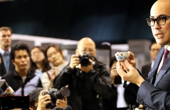 2014年4月8日,蘇富比亞洲區副主席仇國仕在拍賣結束後向記者展示成交的明成化鬥彩雞缸杯並回答記者提問。