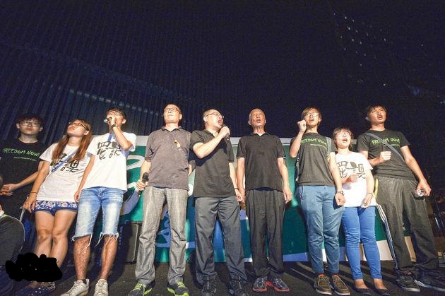 佔中發起人戴耀廷（中）今凌晨1時38分宣布「佔領中環，正式啟動，佔領中環會以佔領政總開始」，又稱「大家準備去飲了，現在即刻開始喎，飲杯！」他與另外兩名發起人陳健民（左四）、朱耀明（右四）及一同站台的學聯成員高呼「飲杯」、「公民抗命，誓不罷休」