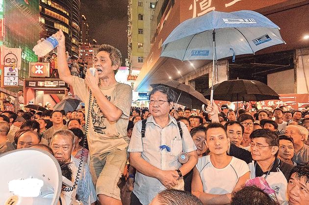 愛港之聲主席高達斌昨身繫藍絲帶(圖中穿恤衫者),與其他反佔中者一同現身旺角衝突現場。他昨呼籲佔中者「見好就收」,又曾表示「如果佢哋(佔中者)唔離開,有乜流血事件,由佢哋自己負責」。