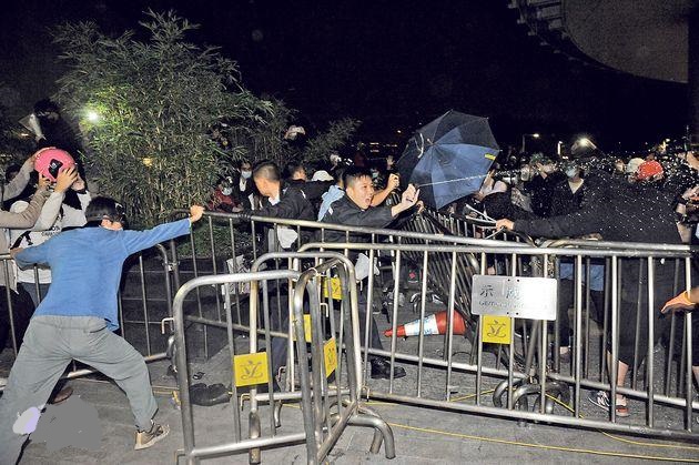 多名蒙面男子抬起鐵欄撞擊破壞玻璃幕牆期間,大批警員趕至,有人以鐵欄阻止警員接近,其中3名警員即施放胡椒噴霧以控制場面。
