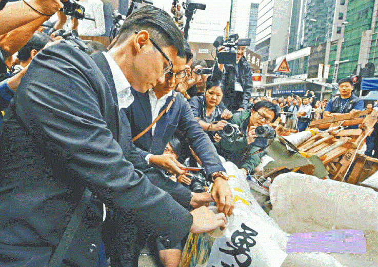 律師樓職員聯同執達主任,到亞皆老街與彌敦道交界張貼禁制令。