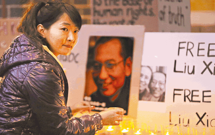 【澳洲】■有示威者在悉尼中國領事館外點上燭光聲援劉曉波。路透社