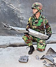 南韓海軍陸戰隊員展示在島上撿獲的北韓火箭殘骸。