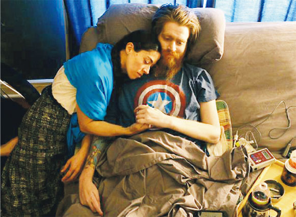 在伊拉克戰爭中重傷癱瘓的前美兵托馬斯(右)目前在善終中心療養,表示將絕食了結餘生。圖為他與妻子(左)互相依偎。